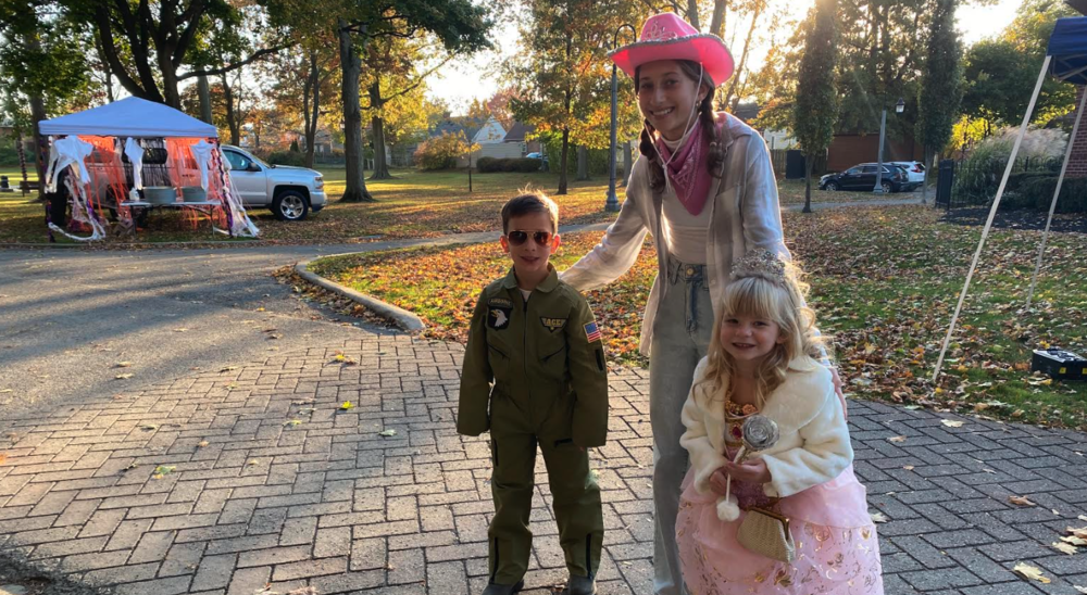 three children with costumes at city halloween event 